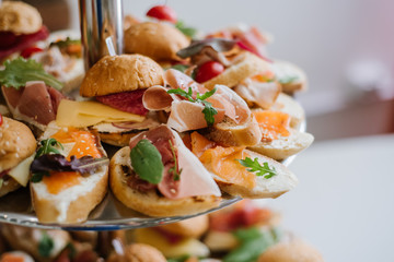 Many little burgers for snack on the buffet table