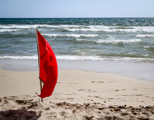 Flaggen am Strand weisen vor Gefahren wie Quallen, Unterströmung und anderen Gefahren hin