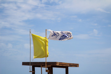 Flaggen am Strand weisen vor Gefahren wie Quallen, Unterströmung und anderen Gefahren hin