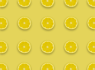 Pattern.Fresh lemon slices on a yellow background.Flat lay, top view - image background.
