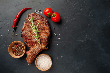 Grilled beef steak with spices on a stone background with copy space