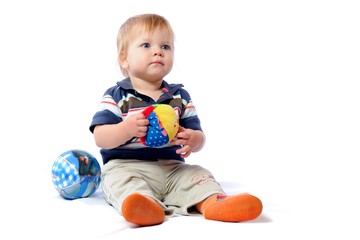 Little toddler plays with loved toy. Boy holding plush ball in hand. Playing with child car. Isolated on white background