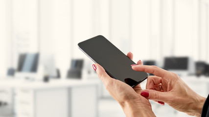 Smartfon, telefon w kobiecych dłoniach na biznesowym tle