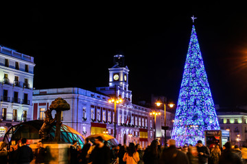 Fototapeta na wymiar Árbol de Navidad y Real casa de correos en la Puerta del Sol de Madrid, España.