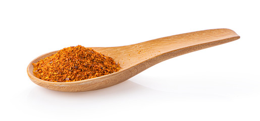 red chili pepper powder in spoon on white background