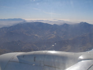 Panorama des marokkanischen atlasgebirges aus dem flugzeug mit sonne und nebelschleiern