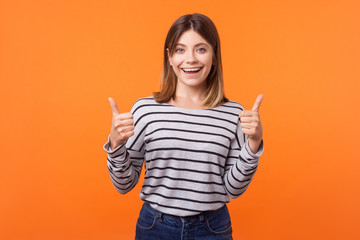 Like, thumbs up! Portrait of joyful kind woman with brown hair in long sleeve striped shirt...