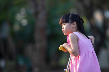 portrait of cute asian girl in park with bokeh nature background.