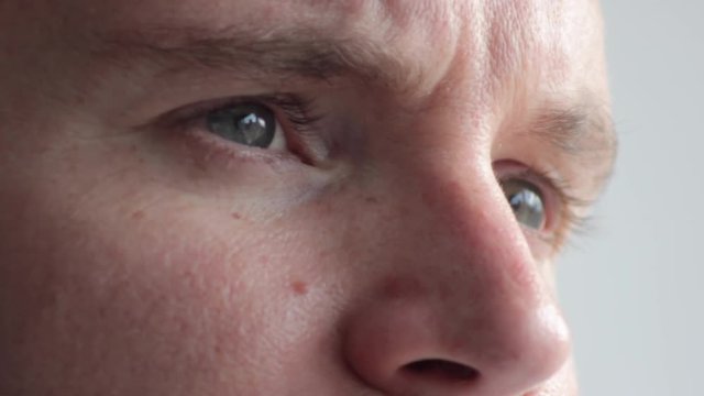 Hopeful redhead bearded man with blue eyes staring, extreme close up tilt