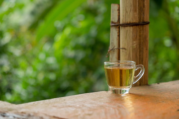 Hot tea in a clear glass placed on the table In the midst of natural atmosphere