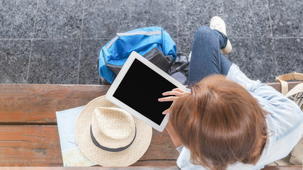 Obraz premium Woman traveler tourist using tablet at train station. Traditional train for transportation.