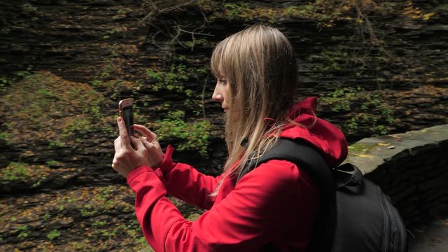 Female tourist taking pictures with phone at Watkins Glen State Park natural gorge