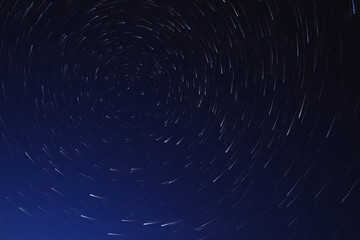 Long exposure starry sky, twisted tracks of stars.