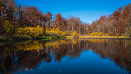 Fototapeta na wymiar Colorful reflection of autumn trees in a mountain lake