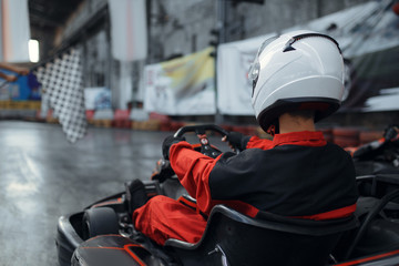 Kart racers in helmet, back view, karting - obrazy, fototapety, plakaty