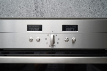 Obraz premium Metallic oven and its control panel with displays for setting the temperature and timer, close-up