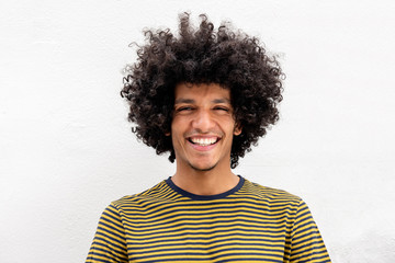 Front portrait of handsome young North African man smiling by white background