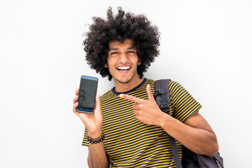 happy young North African man with afro hair showing mobile phone screen and pointing to it