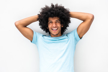 Fototapeta na wymiar handsome young man with afro hair smiling with hands behind head against white background