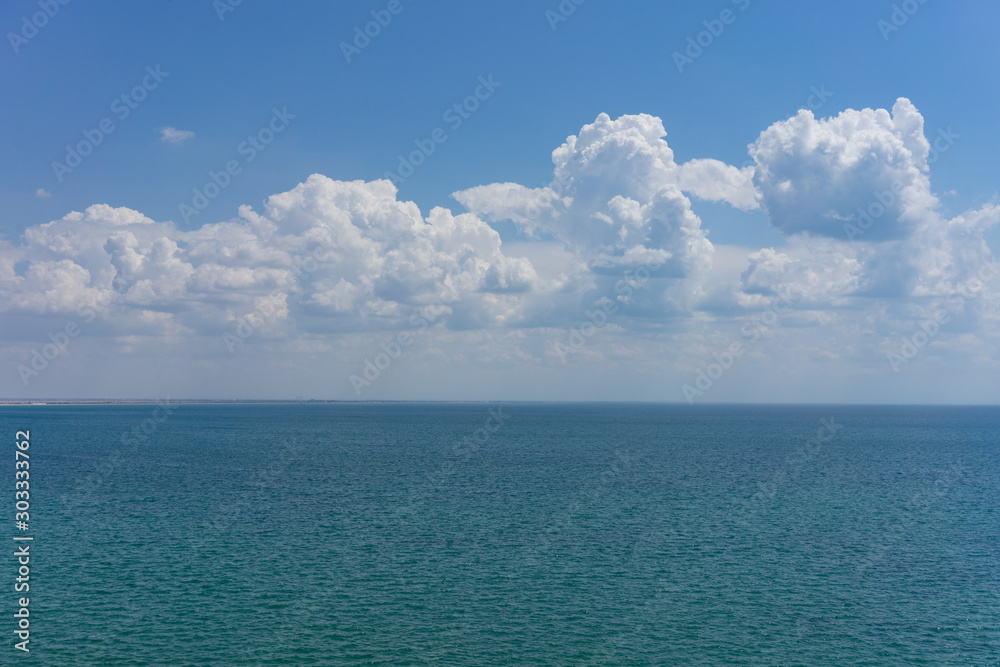 Wall mural seascape with water surface and sky with clouds