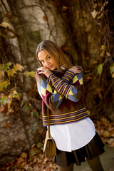 Young woman standing outside at sunny autumn day