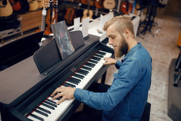 Musician trying to play on piano in music store