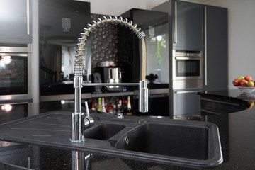Black kitchen sink and chrome tap that can be pulled out for comfortable washing