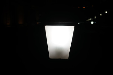 Black background with a glowing white lantern in the middle