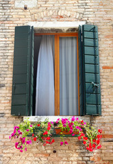 Venice Window with window box planter full of flowers.