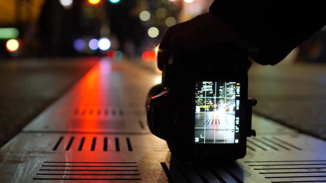 Photographer taking creative picture with dslr of colorful lights on ground 1