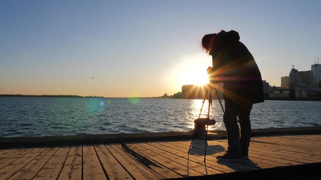 Photographer with tripod and dslr taking photos of Toronto cityscape sunset 2