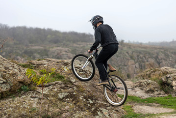 Cyclist on a mountain bike is rising up the rocky terrain.