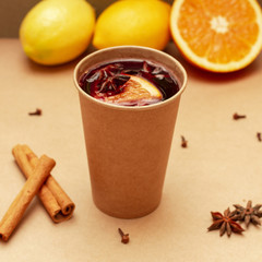 Mulled wine with cinnamon sticks and star anise on a table.- Image
