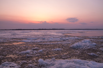 Obraz premium picturesque colorful ice drift on a calm wide river during the pink sunset