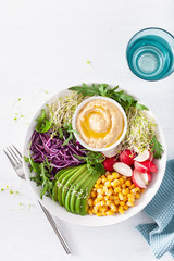 vegan avocado sweet corn lunch bowl with hummus, red cabbage, radish and sprouts