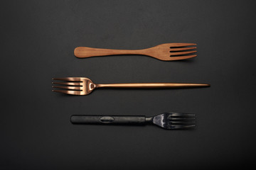 Three different material forks, wooden forks, long handle gold metal forks, black plastic forks