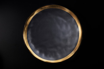 Textured dark grey ceramic plate with gold rim