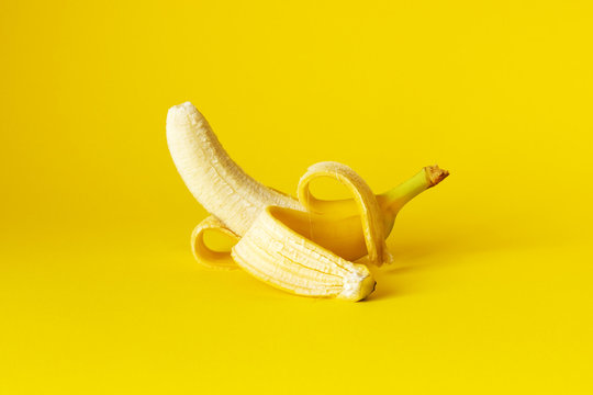 peeled banana on yellow background