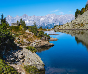 Calm autumn Alps mountain lake with clear transparent water and