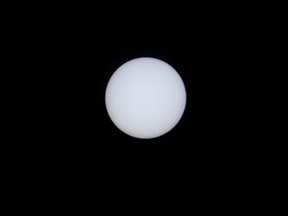 sun through solar filter and telescope with Mercury transiting