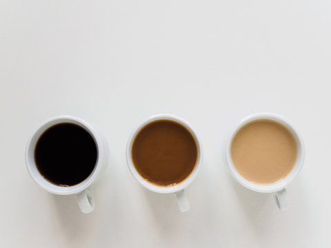 Three cups of different coffee on a white background