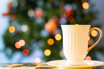 View of cup of tea on the wooden table with chrismas light in chrismas event