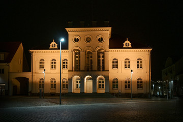 Fototapeta na wymiar Neustrelitz town hall illuminated at night on the market place in the centre of the city, black sky, Mecklenburg-Vorpommern, Germany
