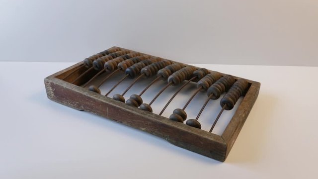 money dollars fly on top of wooden old abacus or wooden bills on a white background. Antique concept.