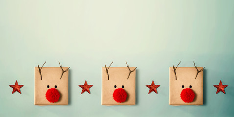 Handmade reindeer pom pom gift boxes - overhead view flat lay
