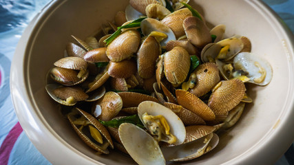 Close up view of the Lala or saltwater clams cooked with oyster sauce, ginger, garlic and onions in a bowl.