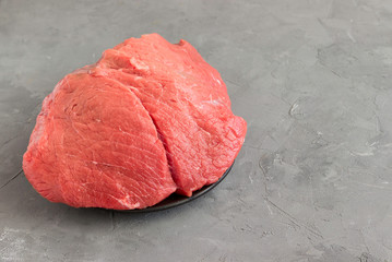Raw beef on a gray table.