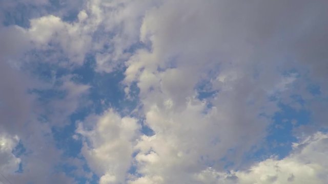 Cloudscape Time Lapse of fluffy grey clouds moving around in blue sky