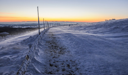 Sunrise in snow covered Jeseniky mountains in Czechia during nice winter with fog and clear sky. Wiew of Czech mountains, trees and snow fields covered in snow and morning sun. Eastern Sudetes, Praded