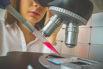 student girl looking in a microscope, science laboratory concept